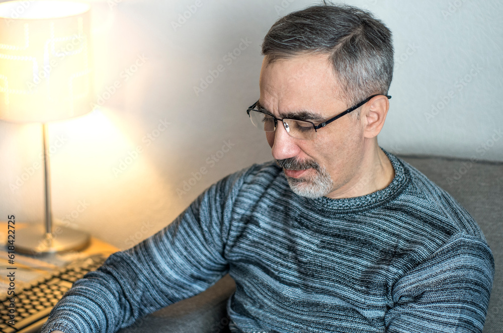 Adult middle aged man. He is wearing a casual sweater. Face with gray beard and thick eyebrows. Chest-length lifestyle portrait of matured caucasian person Adult middle aged man. He is wearing a casual sweater. Face with gray beard and thick eyebrows. Chest-length lifestyle portrait of matured caucasian person