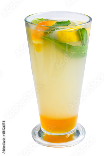Lemonade with lemon slices and mint in a tall glass. Yellow cocktail with citrus