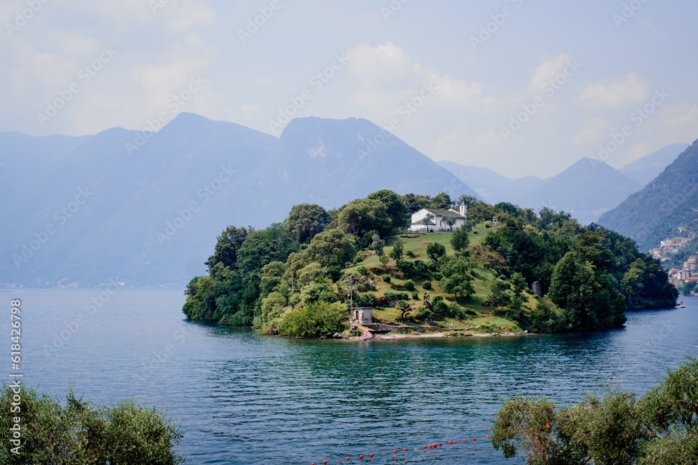 Beautiful scene of  island on the lake Como in Italy. A big blue lake surrounded by green hill.