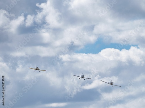 View of airplanes soaring in formation over a landscape of rolling hills and cloudy skies © Daniel Garcia De Marina Bravo/Wirestock Creators