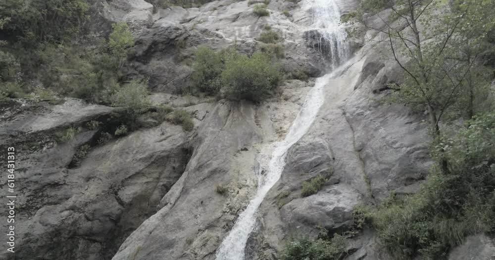 Small waterfall coming down the big rocks into a small water pond Small waterfall coming down the big rocks into a small water pond