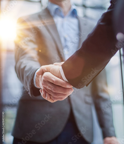 Two diverse professional business men executive leaders shaking hands at office meeting