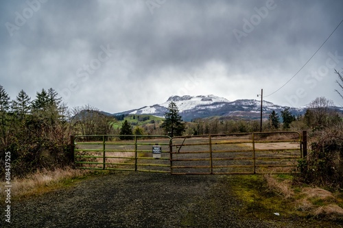 Rustic gate and a dusty dirt road stand in front of a picturesque mountain range near Umpqua