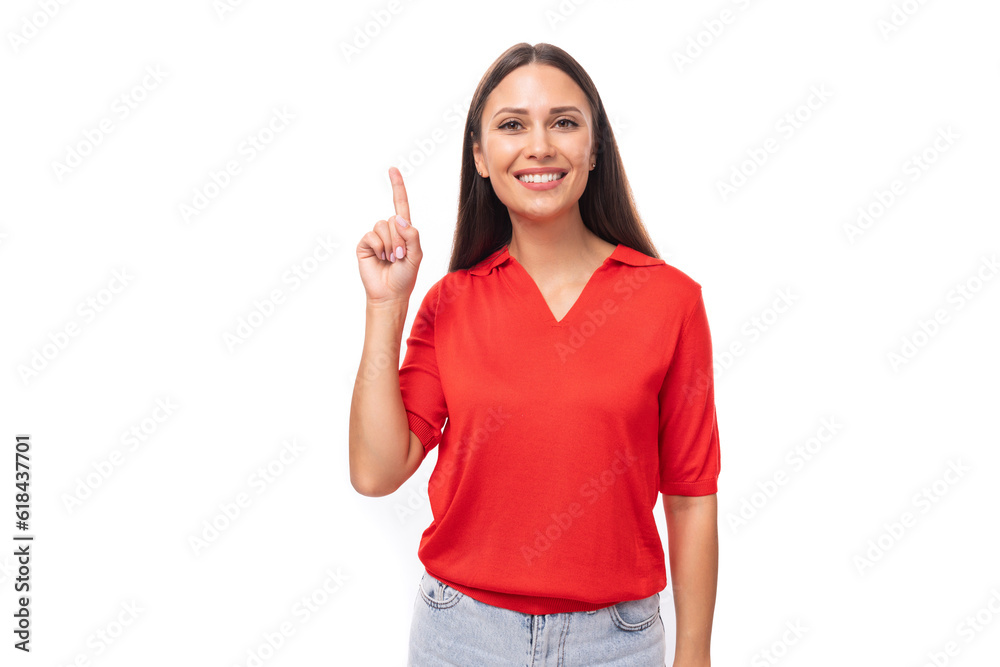 pretty smart caucasian woman with black hair is wearing a red blouse with a halter neckline pointing her finger at the advertising space pretty smart caucasian woman with black hair is wearing a red blouse with a halter neckline pointing her finger at the advertising space