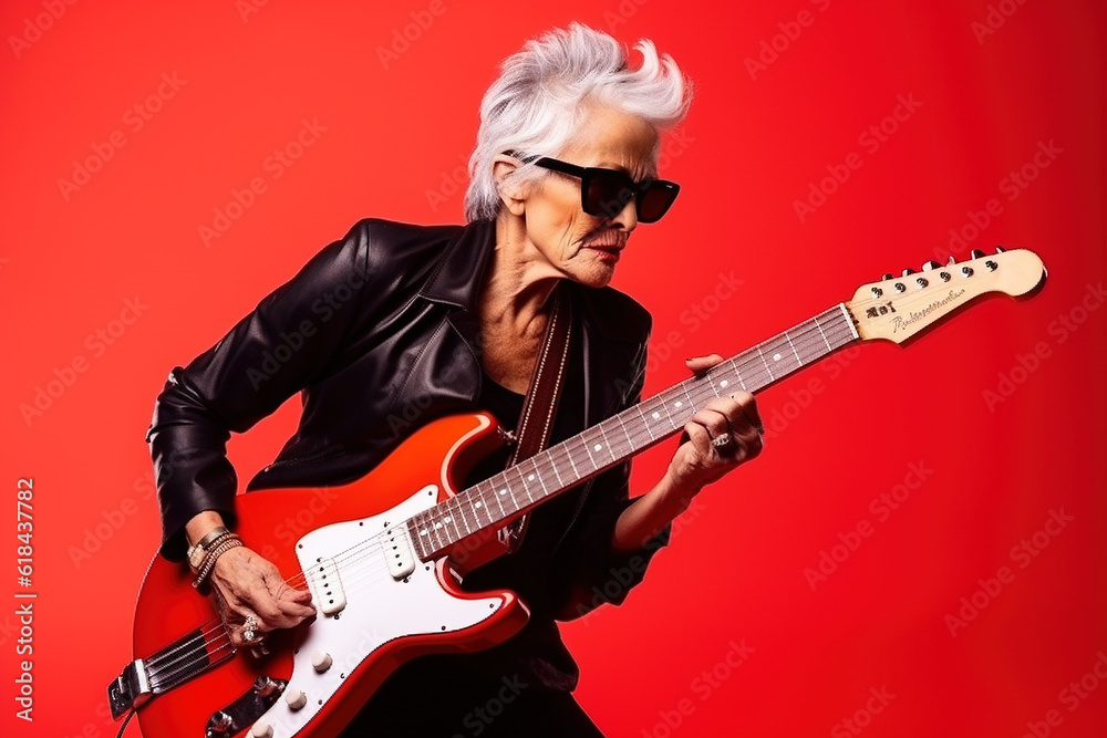 Portrait of a cool trendy old woman playing a guitar on red studio background. Generative AI