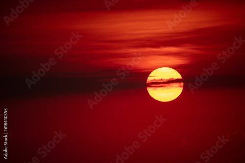 Vibrant setting sun seen in the distant blood red sky  emitting a powerful radiance