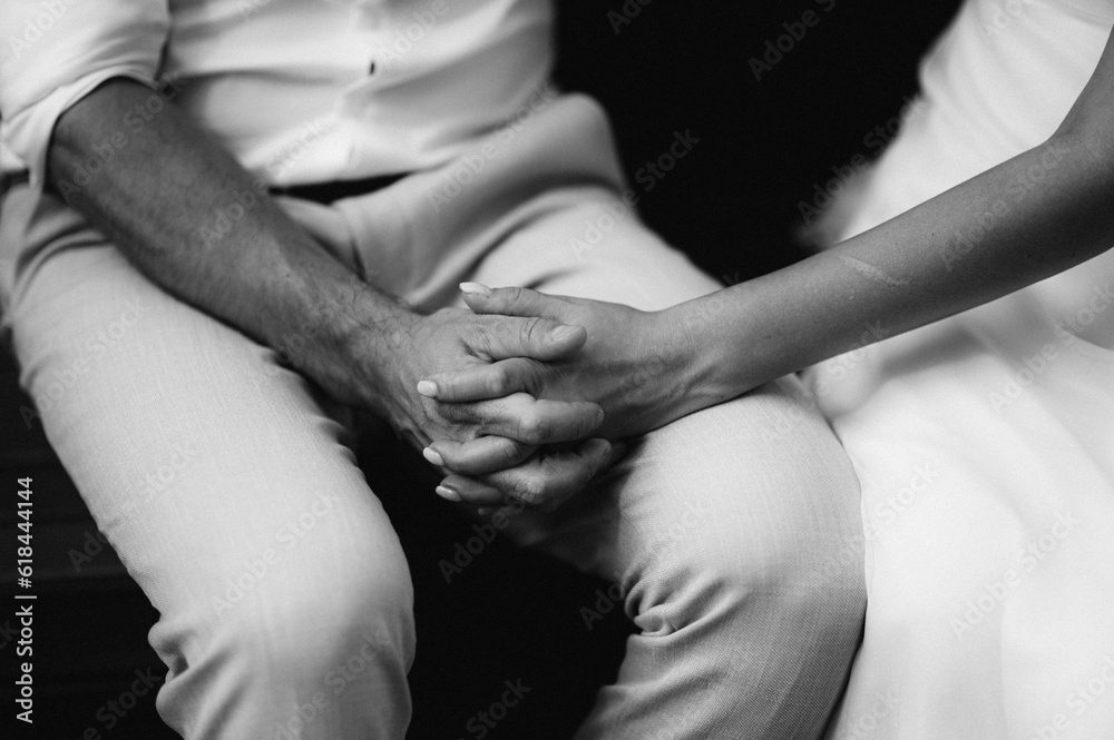 Grayscale shot of a newlywed couple holding hands. Grayscale shot of a newlywed couple holding hands.