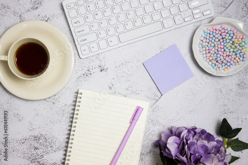 Working items with computer, flowers and coffee over the light marble background.