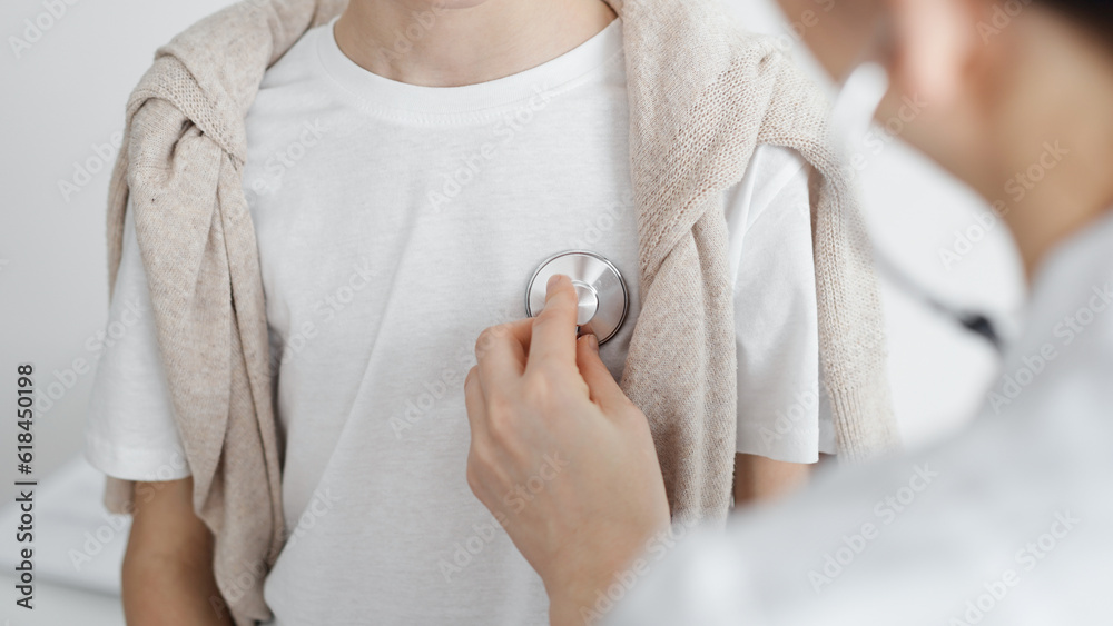 Fototapeta premium Doctor is examining a kid patient with a stethoscope. Perfect health concept in medicine