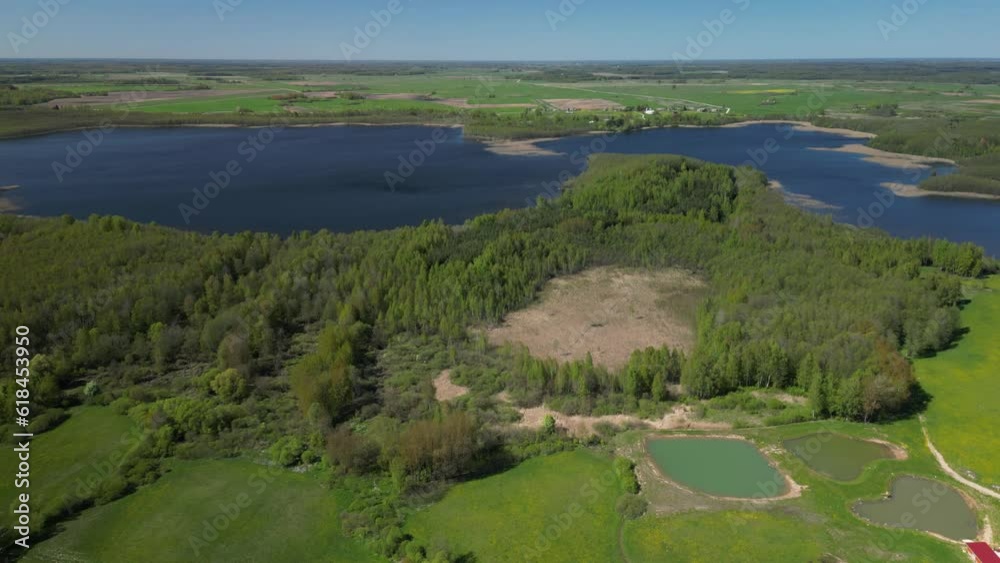 Drone view over a pond between trees and fields Drone view over a pond between trees and fields