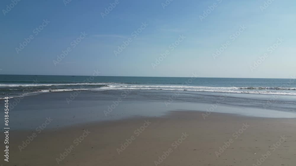 Aerial video of sea waves crashing on a shore on a sunny day Aerial video of sea waves crashing on a shore on a sunny day