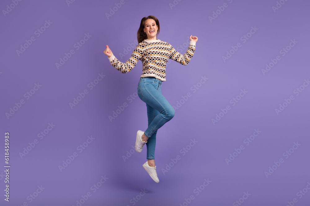 Full body portrait of young excited jumping woman isolated purple color background Full body portrait of young excited jumping woman isolated purple color background