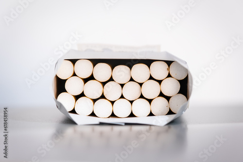Open pack of cigarettes resting on table, front view, white background.