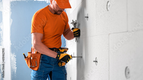 nserting a dowel for thermal insulation to the drilling hole in the mineral insulation board. photo