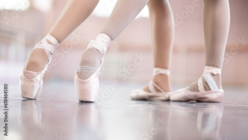 Close-up of the legs of two ballerinas in pointe shoes in a dance class.