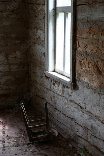 Small fragment of the empty room of the thrown house. Naked walls and dirty floor. Under a window the turned stool lies.