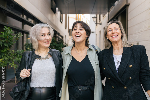Foto Cheerful women friends walking in the city, talking and smiling