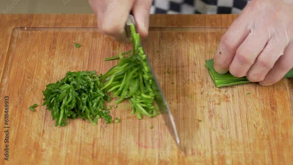 Chef is cutting fresh spinach on a board Chef is cutting fresh spinach on a board