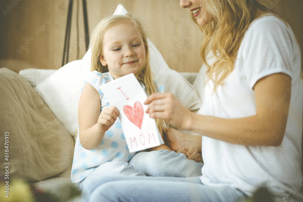 Happy mother day. Child daughter congratulates mom and gives her postcard with heart drawing. Family and childhood concepts Happy mother day. Child daughter congratulates mom and gives her postcard with heart drawing. Family and childhood concepts