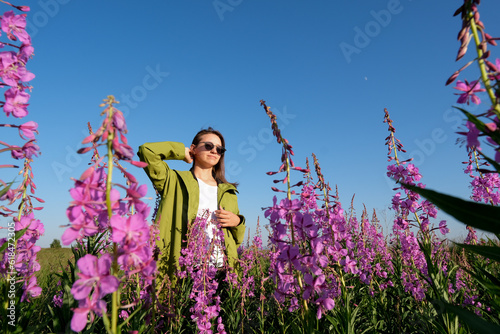 smiling young woman with hat on willow-herb flowers field. happiness, nature, summer, vacation concept