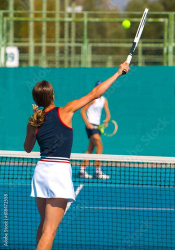 A girl plays tennis on a court on a summer sunny day © Павел Мещеряков