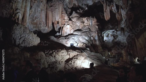 Tourists explore a cave with a beautiful background