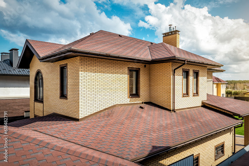 Obraz na plátne Modern roof with new roof shingles under cloudy sky