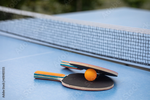 Table tennis. Blue ping pong table. Ping pong rackets and ball. The concept of sport and healthy lifestyle.