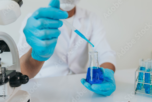Close-up shot of male doctor using dropper in laboratory