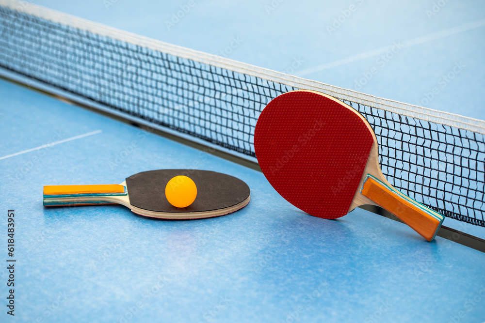 Table tennis. Blue ping pong table. Ping pong rackets and ball. The