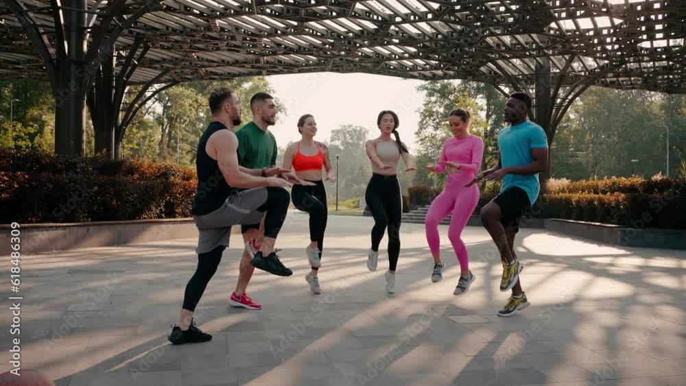 Smiling young athletes do morning exercises in city park Smiling young athletes do morning exercises in city park