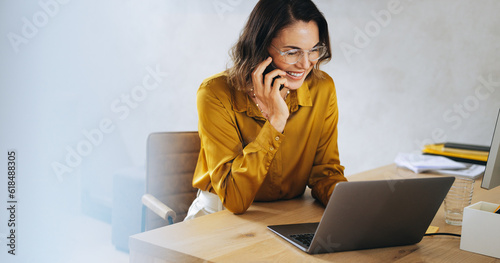 Successful businesswoman making a professional phone call in her office photo