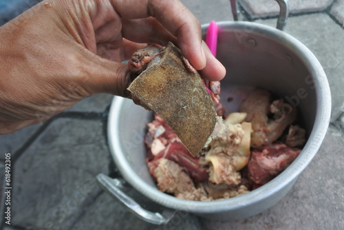 Close up photo of a hand holding Eid ul Adha slaughtering meat with skin texture