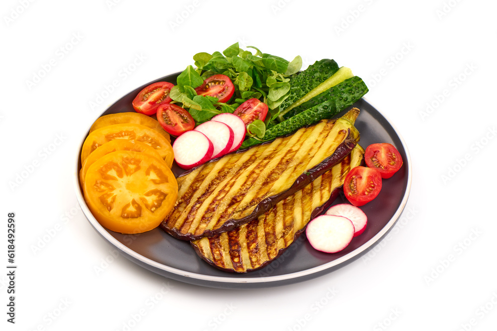 Grilled spicy eggplants on a black plate, isolated on white background. Grilled spicy eggplants on a black plate, isolated on white background.