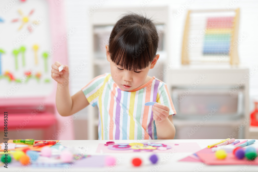 Fototapeta premium young girl making paper craft for homeschooling