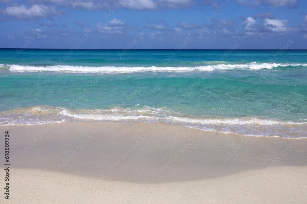 Empty sea beach with white sand, view to azure waves and blue sky with clouds. Caribbean coast, Background for holidays on a paradise nature