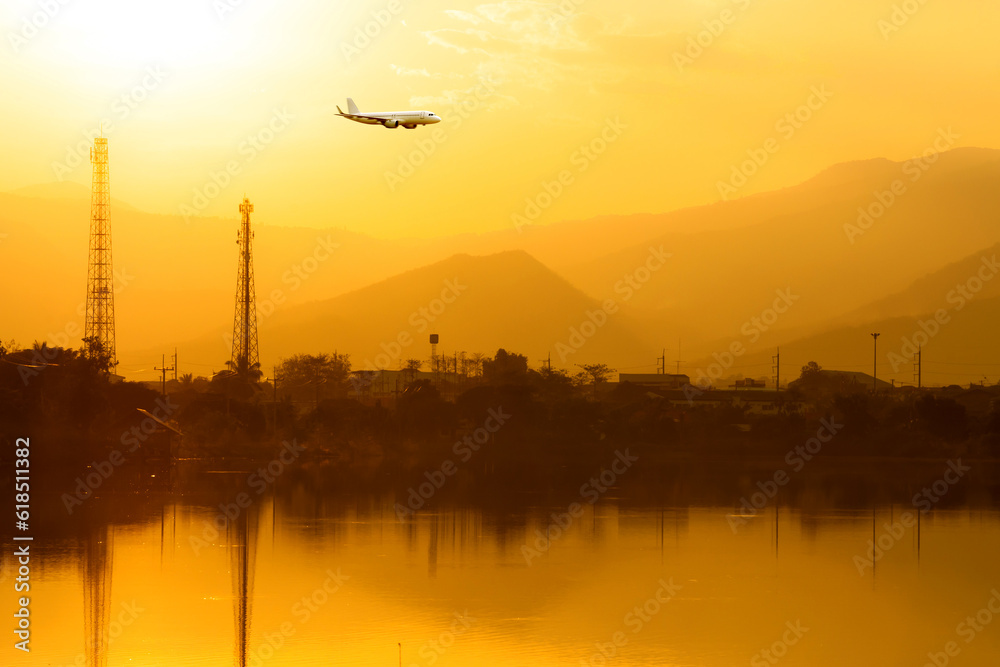 Fototapeta premium Commercial airplane above sea with sunset in summer season over beautiful scenery lagoon background, Concept business travel and transportation summer vacation travel.