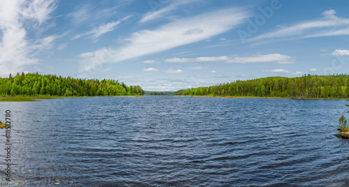 See mit Blauem Himmel und Wald