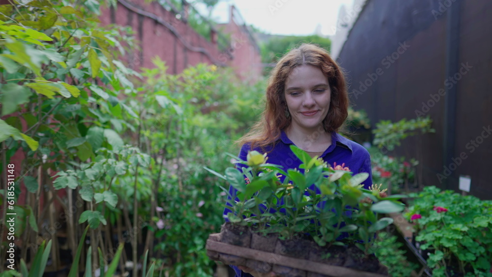 Happy young woman walking in Plant Store while carrying basket with pots of flowers. One female customer buying plants Happy young woman walking in Plant Store while carrying basket with pots of flowers. One female customer buying plants
