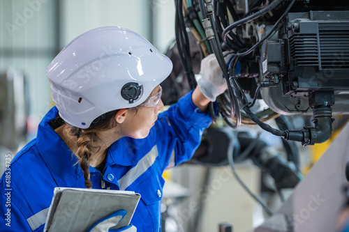 Tela woman engineer in uniform helmet inspection check control heavy machine robot arm construction installation in industrial factory