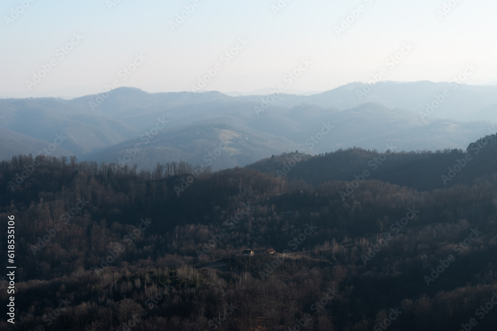Landscape with village house surrounded with forest against mountain in haze, mountain Ljubic near Prnjavor