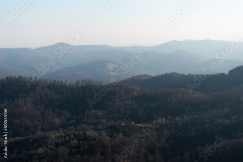 Landscape with village house surrounded with forest against mountain in haze, mountain Ljubic near Prnjavor