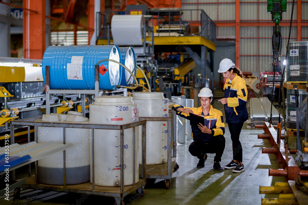 Foto De Two Young Engineer Assistant In Helmet Inspection Check Heavy foto-de-two-young-engineer-assistant-in-helmet-inspection-check-heavy