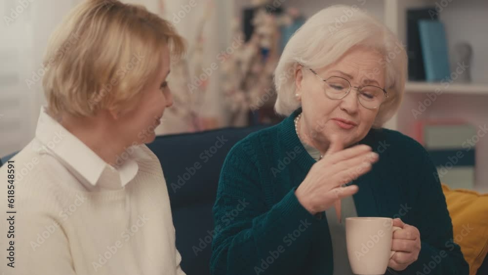 Senior woman and her adult daughter talking at home, time with family, weekend Senior woman and her adult daughter talking at home, time with family, weekend