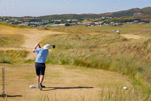 Man driving a golf ball off a tee in donegal Ireland 
