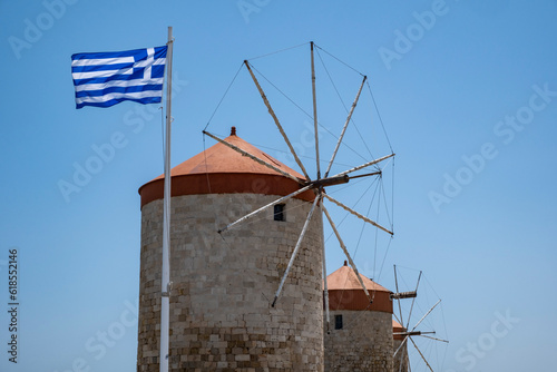 Closeup of the Three Ancient Windmills and the Greek Flag Against the Blue Sky Near the Harbor of Rhodes, Greece