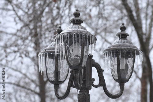 Street light with icicles is frozen. Icing  city park on a winter day after freezing rain in Mykolaiv.