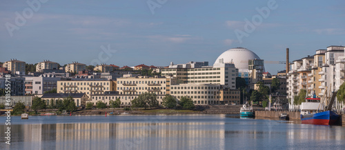 Piers with boats and ferries, apartment houses and the Globe Avicii arena, apartment and bridge, a sunny summer morning in Stockholm photo