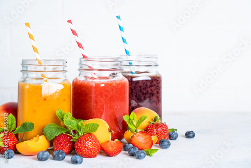 Smoothie set with fresh fruits and berries at white background. Homemade healthy drink.