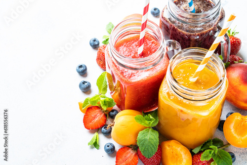 Smoothie set with fresh fruits and berries at white background. Homemade healthy drink.